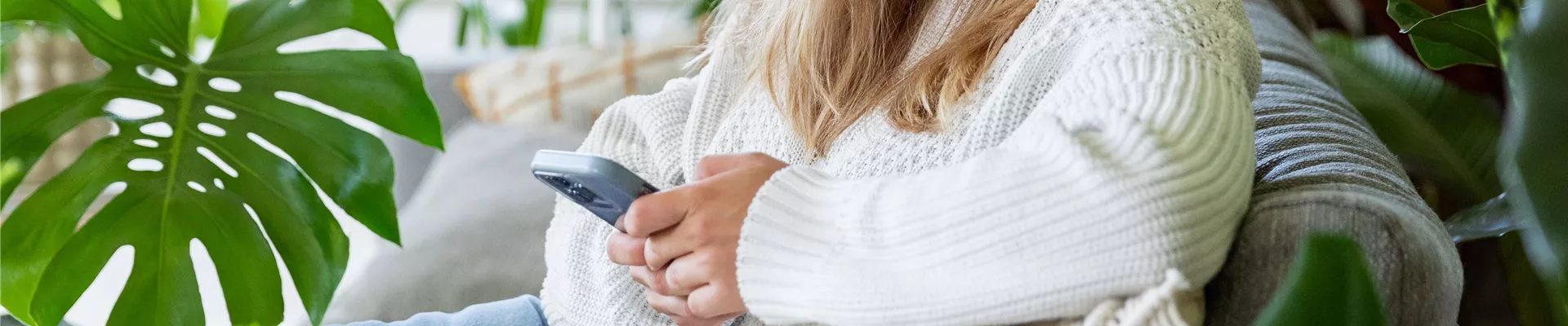 Jungle Ambiente - Frau mit Handy auf dem Sofa