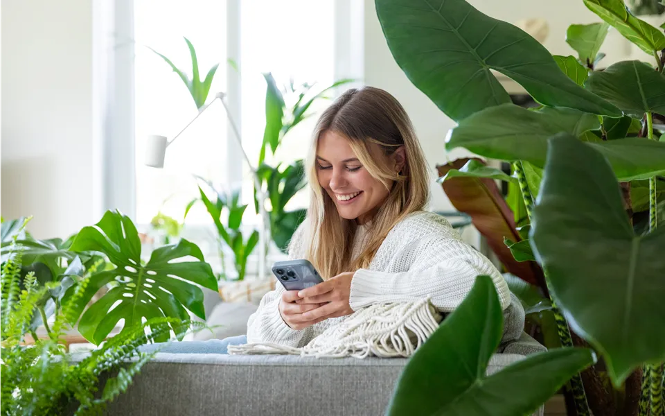 Jungle Ambiente - Frau mit Handy auf dem Sofa